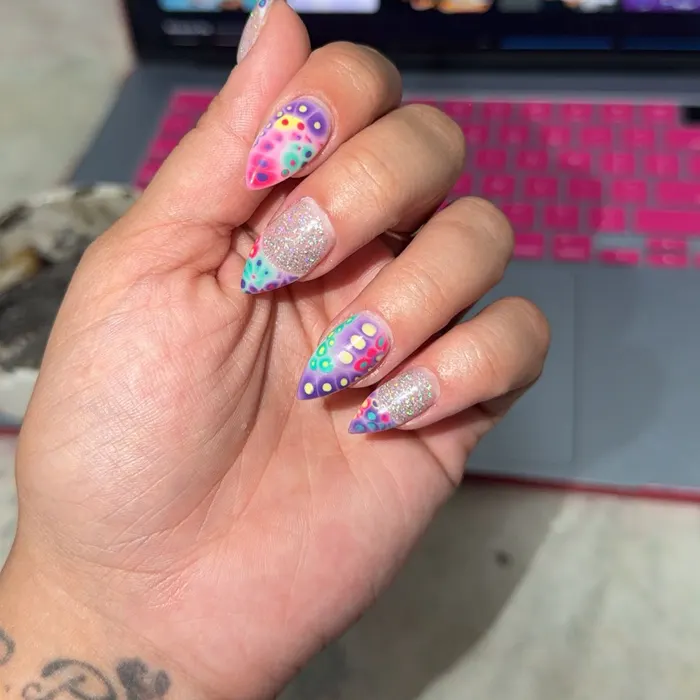 Stiletto almond nails with pink, purple and teal dotted aura art and silver glitter accent nails
